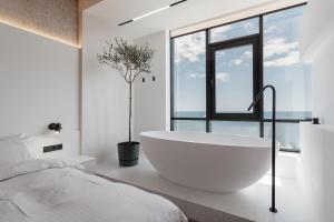 a white bathroom with a tub and a window at Sea and Sky Apartment in Odesa