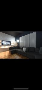 a living room with a couch and a television at Swan Street Townhouse Hot Tub & Roof Terrace in Manchester