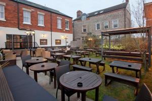 restauracja ze stołami, krzesłami i budynkami w obiekcie The Goddard Arms w mieście Swindon