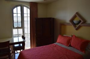 - une chambre avec un lit, une table et une fenêtre dans l'établissement Hotel Real Santa Fe, à San Juan de los Lagos