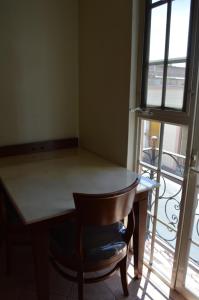 una mesa y una silla en una habitación con ventana en Hotel Real Santa Fe, en San Juan de los Lagos