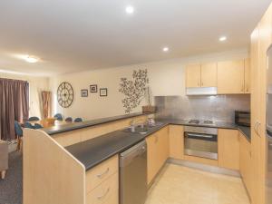a kitchen with a sink and a stove top oven at Silvertrees 2 1 McLure Cir in Jindabyne