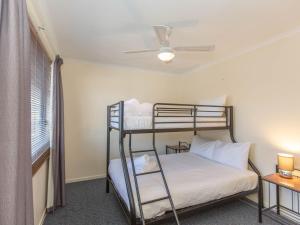 a bedroom with two bunk beds and a window at Silvertrees 2 1 McLure Cir in Jindabyne