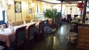 una sala da pranzo con tavoli, sedie e una pianta di Hotel zur guten Quelle a Selters