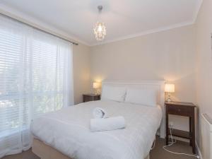a bedroom with a white bed with two towels on it at St Helenas 5 Twynam Street in Jindabyne