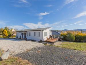a small white house on a gravel driveway at St Helenas 5 Twynam Street in Jindabyne