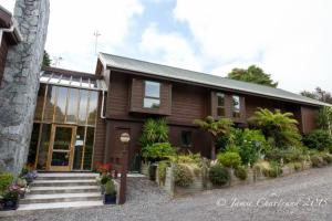 a brown house with stairs and plants in front of it at Dakune Lodge in Ohakune