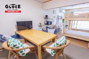 Habitación con mesa, sillas y litera en GLOCE 美幌 ゲストルーム l BIHORO Guest room en Bihoro