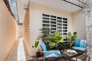 un patio con 2 sillas, una mesa y plantas en El depa de Acuario, en Cancún