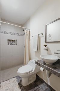 a bathroom with a white toilet and a sink at El depa de Acuario in Cancún