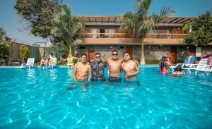 a group of men standing in a swimming pool at Hotel Campo & Leña in Cieneguilla