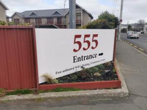 a sign for an entrance on the side of a road at 555 Motel Dunedin in Dunedin