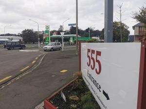 555 Motel Dunedin في دنيدن: وجود علامة لوجود صيدلية على جانب الطريق