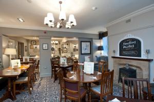 a restaurant with tables and chairs and a fireplace at The Goddard Arms in Swindon