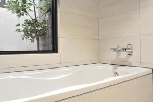 台中的住宿－逢甲K行旅（久窩旅店），带窗户的浴室内的白色浴缸