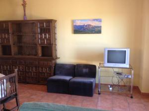 a living room with a chair and a tv at Apartaments la Fabrica in Horta de San Joan