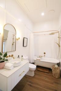a white bathroom with a tub and a toilet and a sink at Waukivory Estate - The Cottage 