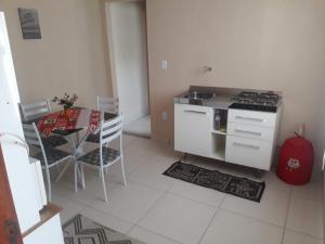 a kitchen with a stove and a table with chairs at Apto Jockey 4 in Campos dos Goytacazes +7 photos
