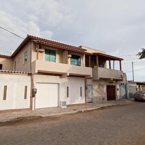 a house on a street with a car parked in front at Apto Jockey 4 in Campos dos Goytacazes