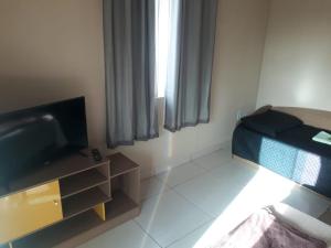 a small room with a bed and a television at Apto Jockey 4 in Campos dos Goytacazes