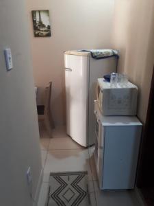 a small kitchen with a refrigerator and a microwave at Apto Jockey 3 in Campos dos Goytacazes