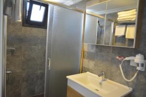 a bathroom with a sink and a mirror and a shower at Ege Apart & Hotel in Ayvalık