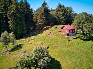 uma casa vermelha no topo de uma colina com árvores em Holiday home bremnes II em Bremnes