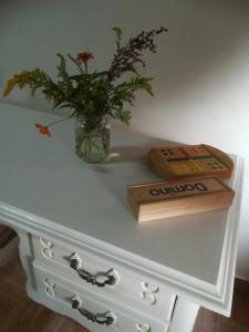 a table with a vase with flowers and a wooden box at Ruralna kuća za odmor Pozojova hiža - Rural Holiday House in Lopatinec