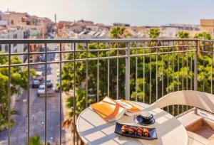 a table on a balcony with a view of a city at Numa Hotel Jaffa in Tel Aviv