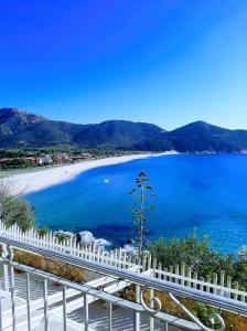 een uitzicht op een strand met een wit hek bij B&B is pranus a mari casa privata in Solanas