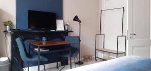 a bedroom with a desk and a table with a television at verzorgde kamer in monumentenpand in Arnhem +7 photos