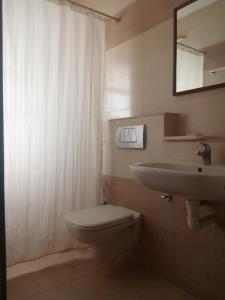 ein Badezimmer mit einem WC, einem Waschbecken und einem Spiegel in der Unterkunft Kohinoor Hotels in Erode