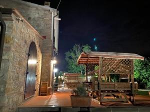 a patio with a bench and an umbrella at night at La Mariola Apartments in Santa Luce