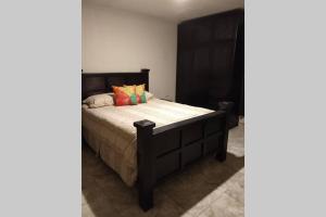 a bedroom with a bed with a wooden headboard at Departamento las palmas in Rosarito