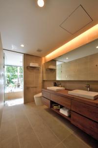 Baño con 2 lavabos y espejo en Villa VALIOSA ON THE BEACH en Onna