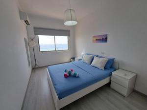 um quarto com uma cama azul com duas chávenas em Super Modern Beachfront 1 bedroom - sleeps 4 em Limassol