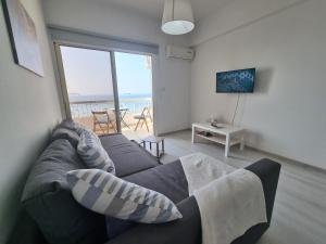 uma sala de estar com um sofá e vista para o oceano em Super Modern Beachfront 1 bedroom - sleeps 4 em Limassol
