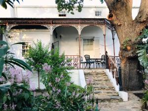 a porch with a table and chairs on a house at The Victorian of Church Street - Cape Dutch Quarters in Tulbagh