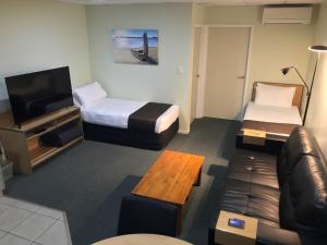 a hotel room with two beds and a couch at Bay of Islands Gateway Motel & Apartments in Paihia