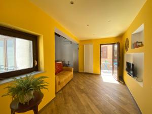 ein gelbes Wohnzimmer mit Sofa und TV in der Unterkunft Monolocale Sant'Andrea in Palermo