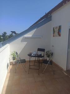 a patio with a table and chairs on a roof at Fantástico ático con terraza, garaje, wifi, con todo para playa, piscina y casa y no facturar maletas! in El Portil