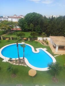 an overhead view of a swimming pool in a yard at Fantástico ático con terraza, garaje, wifi, con todo para playa, piscina y casa y no facturar maletas! in El Portil