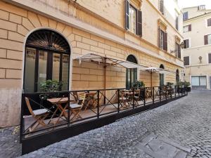 een rij tafels en parasols buiten een gebouw bij Navona Street Hotel in Rome