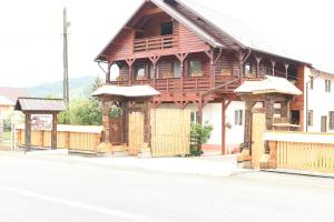 a large wooden building on the side of a street at Pension Ioana Lavita in Vadu Izei