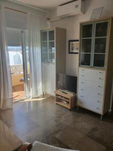 een woonkamer met een dressoir en een tv bij Apartamento en Isla Cristina Puerto Deportivo in Isla Cristina
