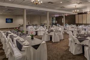 une salle de banquet avec des tables blanches et des chaises blanches dans l'établissement Sea to Sky Hotel and Conference Centre, à Squamish