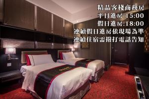 Forbidden City Motel في تايتشونغ: سريرين في غرفة الفندق مكتوب على الحائط
