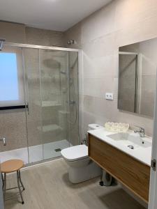 een badkamer met een douche, een toilet en een wastafel bij Casa Rural Camino de la Data in Valencia de Alcántara