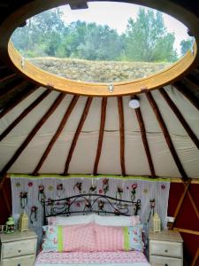 a room with a bed in a yurt with a window at Woodpecker Yurt in Santa Cruz do Douro