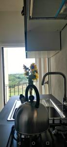 a tea kettle on a stove with a vase of flowers at La casa di Isola in Peccioli +24 photos
